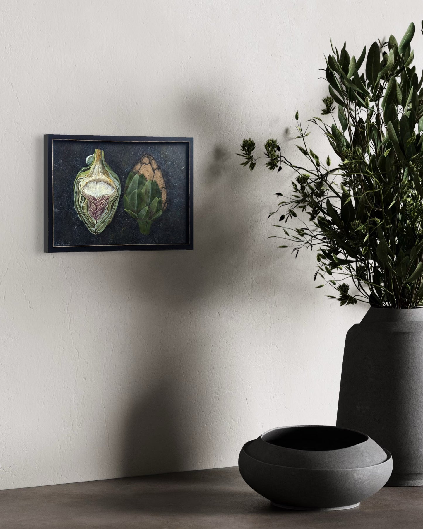 Framed artwork of two artichokes on a dark background. By Adi Radai