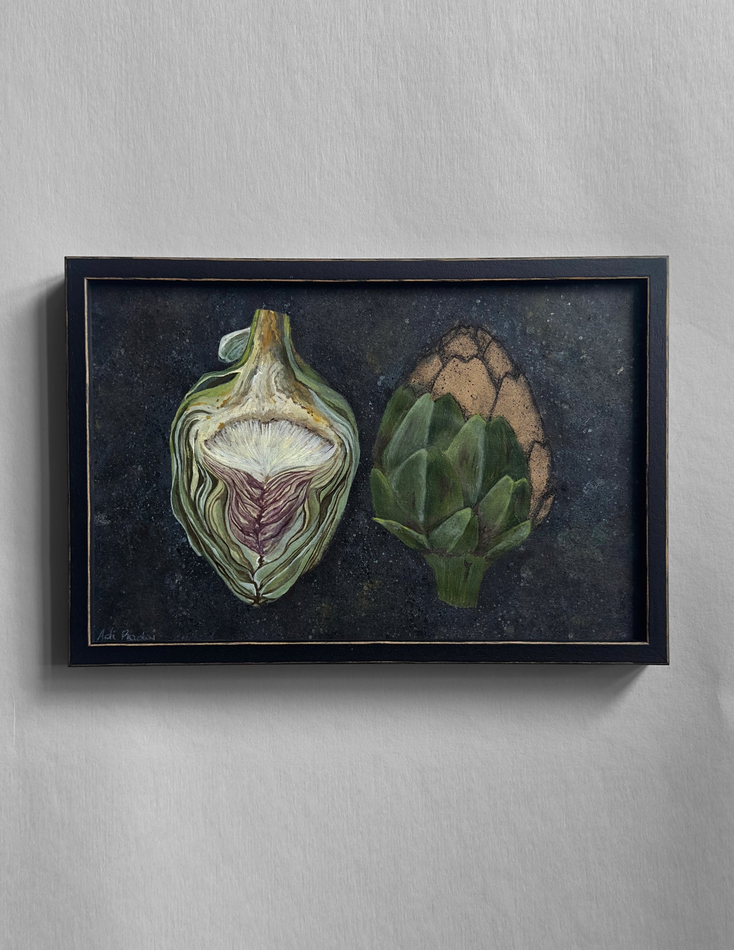 Framed artwork of two artichokes on a dark background. By Adi Radai