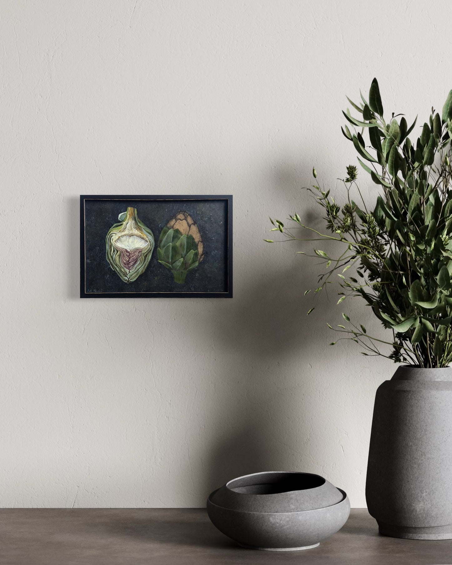 Framed artwork of two artichokes on a dark background. By Adi Radai